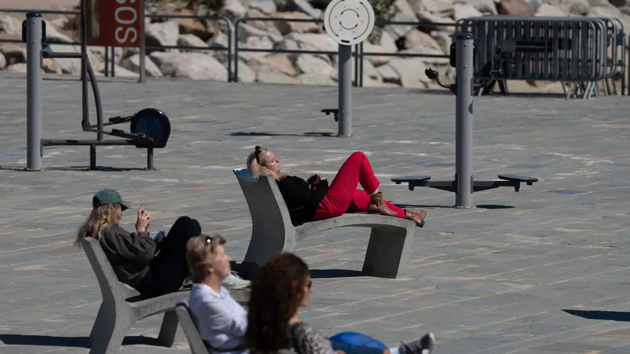 Archivo - Varias personas toman el sol en el paseo mar&iacute;timo de la playa del Bogatell, a 15 de abril de 2024, en Barcelona, Catalunya (Espa&ntilde;a). 