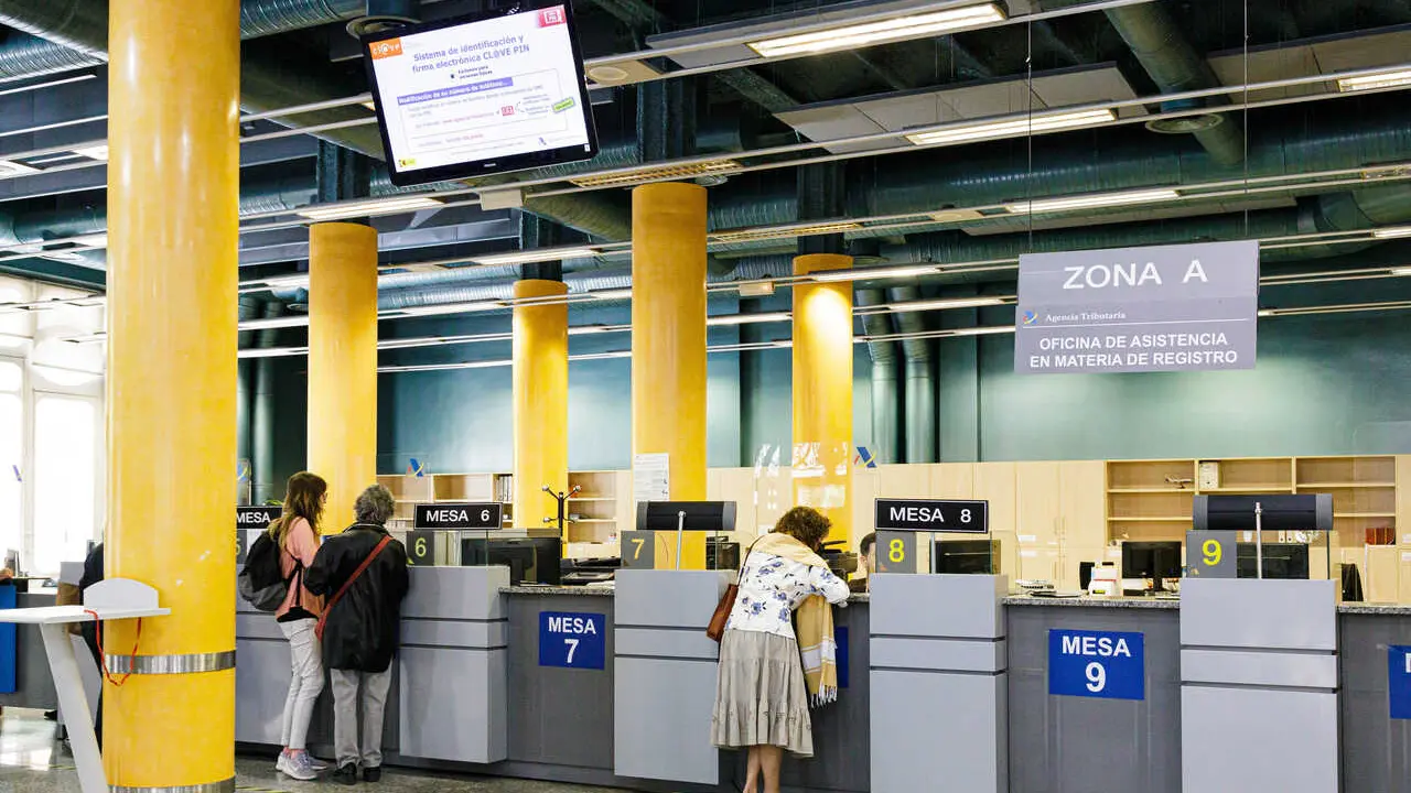 Archivo - Varias personas en una oficina de la Agencia Tributaria