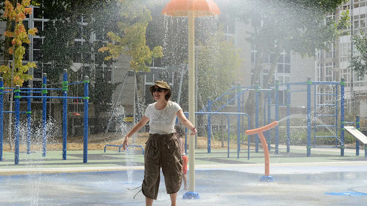 OLA DE CALOR EN OURENSE, UNA SEMANA. FUENTE DE CHORROS EN EL PARQUE INFANTIL "ALAMEDA DO CRUCEIRO", EN EL CENTRO DE LA CIUDAD, UNA DE LAS DOS QUE TIENE ACTIVADOS LOS CHORROS DE AGUA EN TODA LA CIUDAD. VISITANTE PROCEDENTE DE CATALU&Ntilde;A SE REFRESCA.OURENSE 14/07/22. FOTO ROSA VEIGA