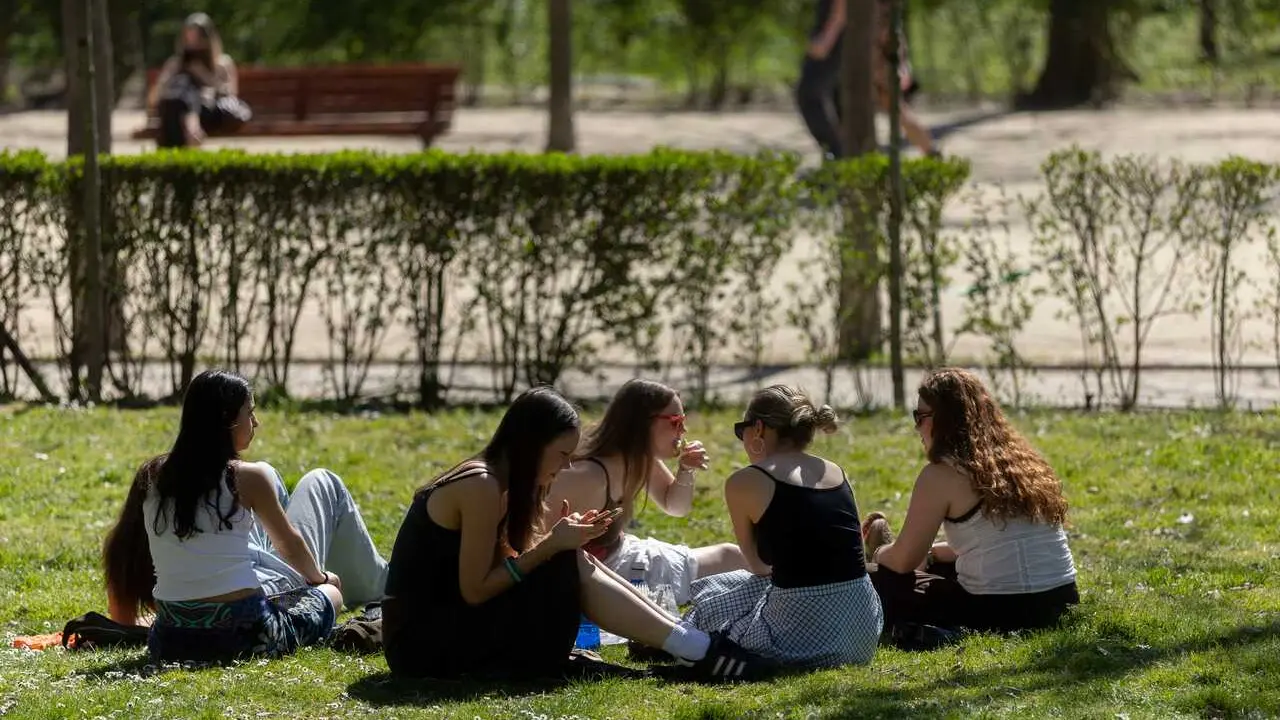 Un grupo de personas sentadas en el c&eacute;sped de un parque, a 17 de marzo de 2026, en Madrid (Espa&ntilde;a).
