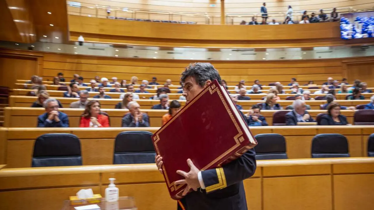 Ujier del Senado retira la Constituci&oacute;n espa&ntilde;ola del sal&oacute;n del pleno despu&eacute;s del juramento de un nuevo senador. 21/10/2025.