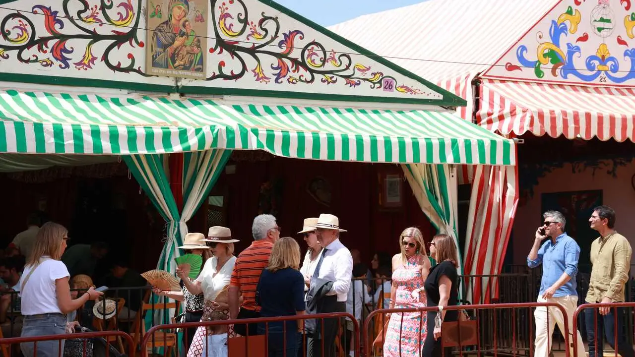 Varias personas pasean por el Real en la Feria de Abril.