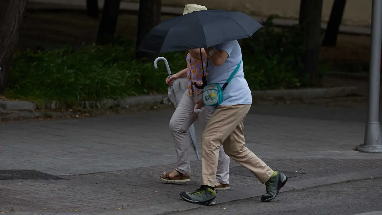 Archivo - Dos personas se protegen de la lluvia con un paraguas, a 8 de junio de 2024, en Madrid (Espa&ntilde;a). 
