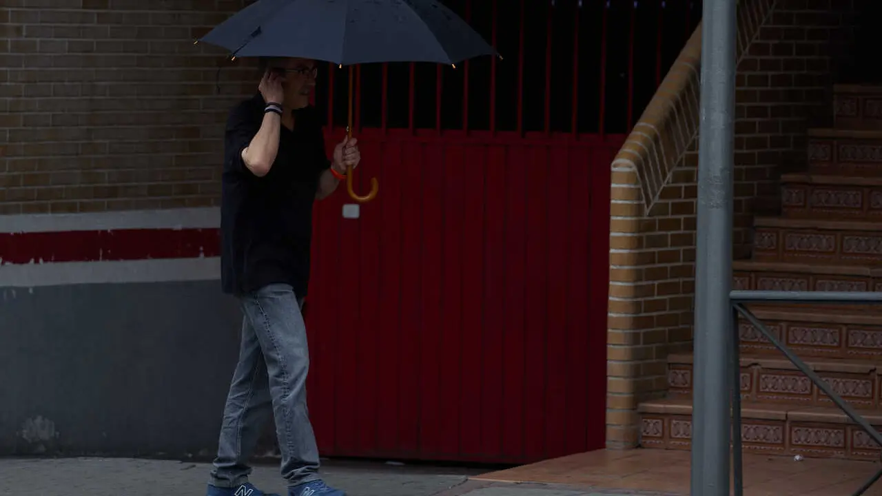 Archivo - Un hombre se protege de la lluvia con un paraguas, a 8 de junio de 2024, en Madrid (Espa&ntilde;a).