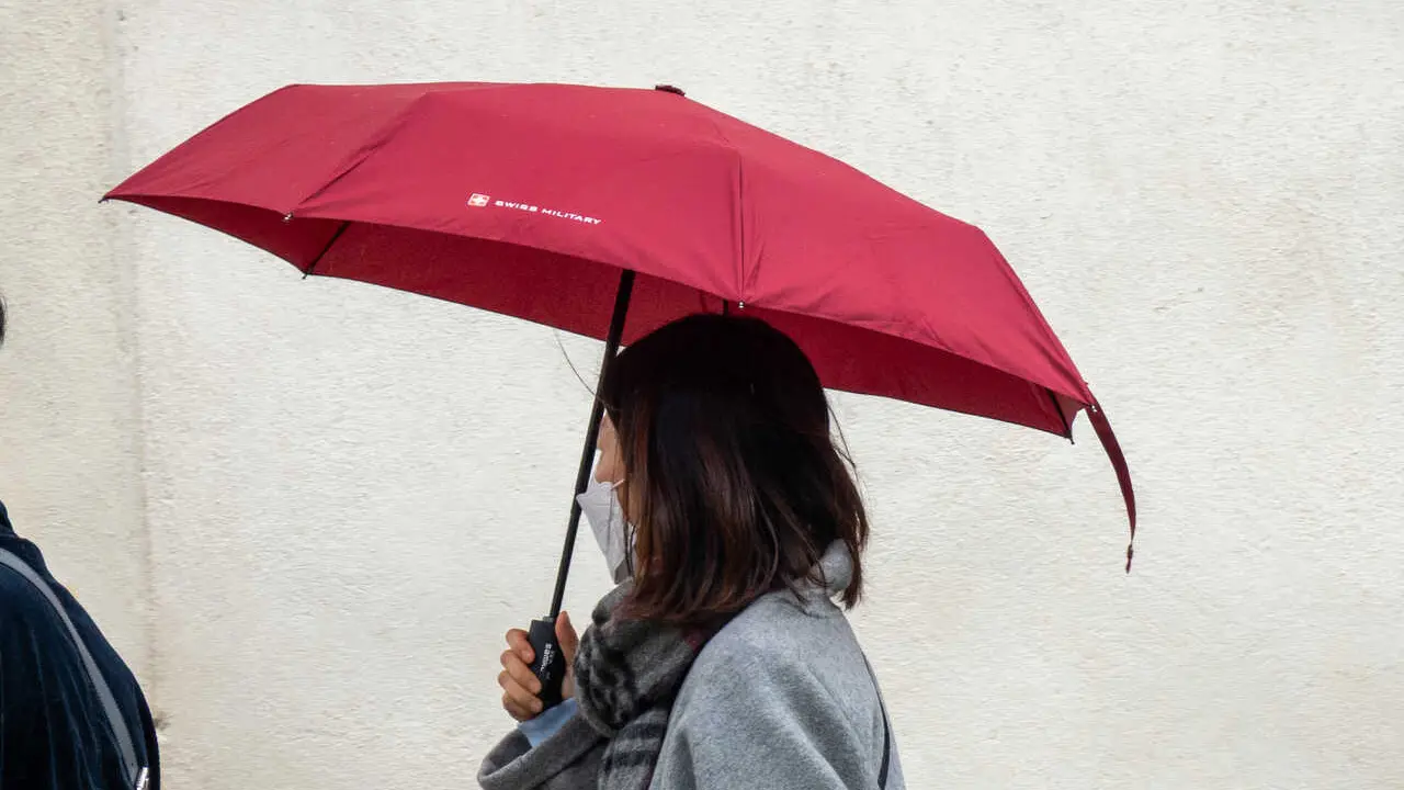 Turistas con paraguas por el centro de la ciudad  durante la llegada de una nueva borrasca que trae polvo en suspensi&oacute;n. A 07 de abril del 2026 en Sevilla, Andaluc&iacute;a (Espa&ntilde;a). 