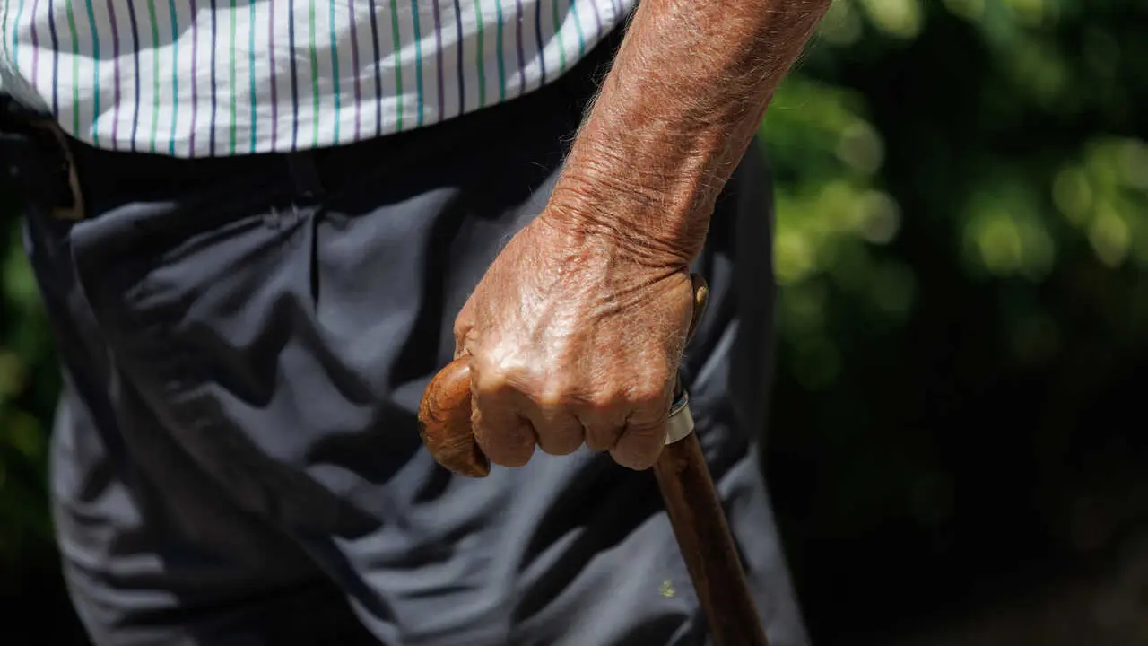 Archivo - Un hombre mayor pasea apoy&aacute;ndose en un bast&oacute;n en Madrid.