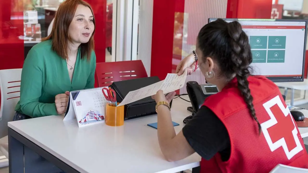 Personal de Cruz Roja asesora a una mujer en materia de empleo.