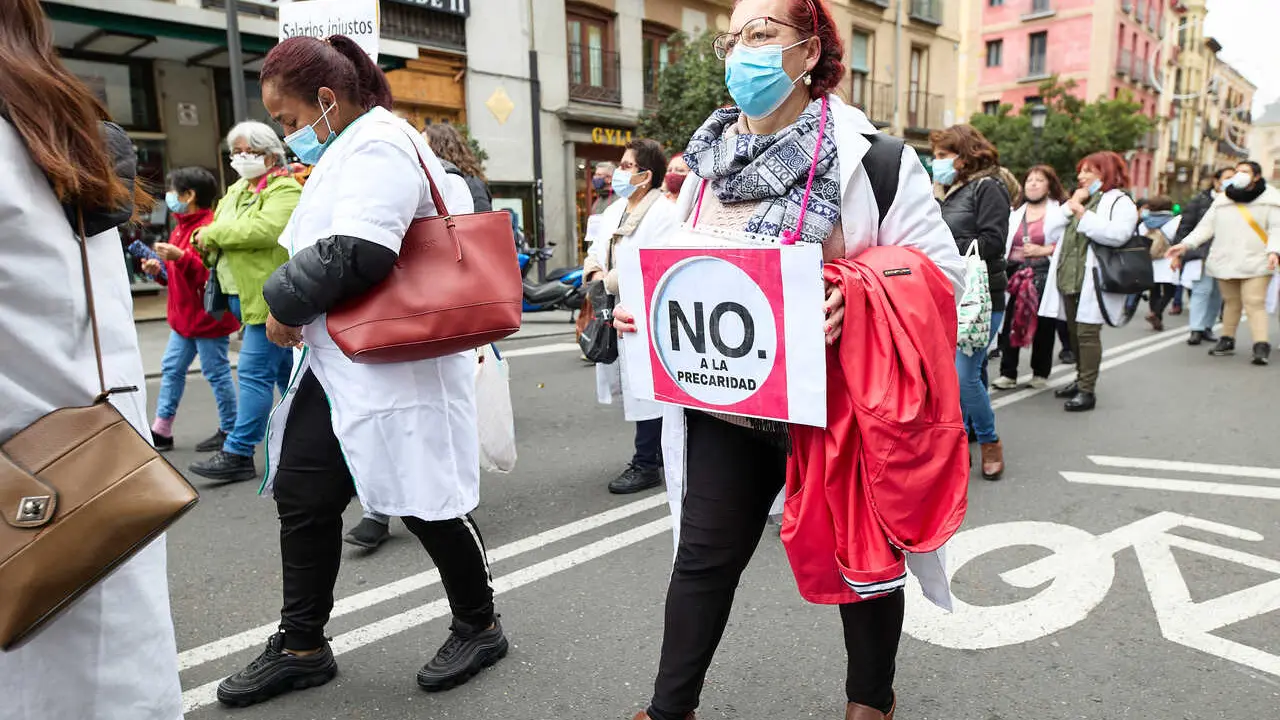Archivo - Una mujer sostiene una pancarta donde se lee 'No a la precariedad', en una manifestaci&oacute;n de profesionales sociosanitarias, a 21 de noviembre de 2021, en Madrid (Espa&ntilde;a). 