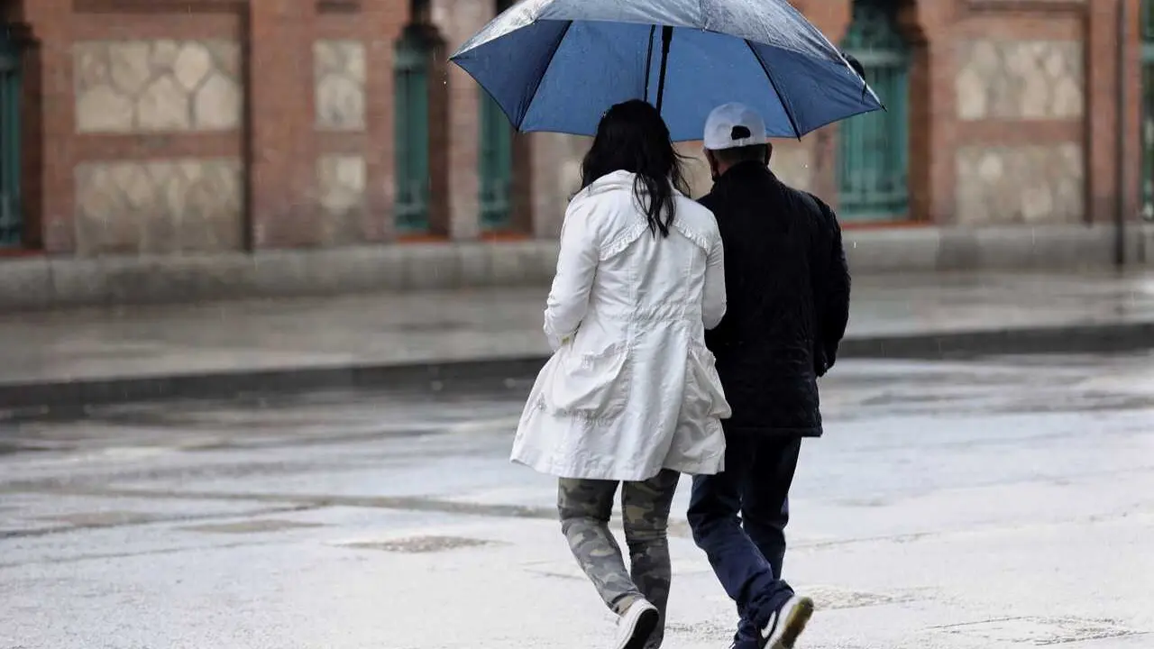Archivo - Varias personas caminan con paraguas el d&iacute;a en que han puesto en aviso amarillo a la Comunidad de Madrid por tormentas y lluvias, a 2 de mayo de 2022, en Madrid (Espa&ntilde;a). 