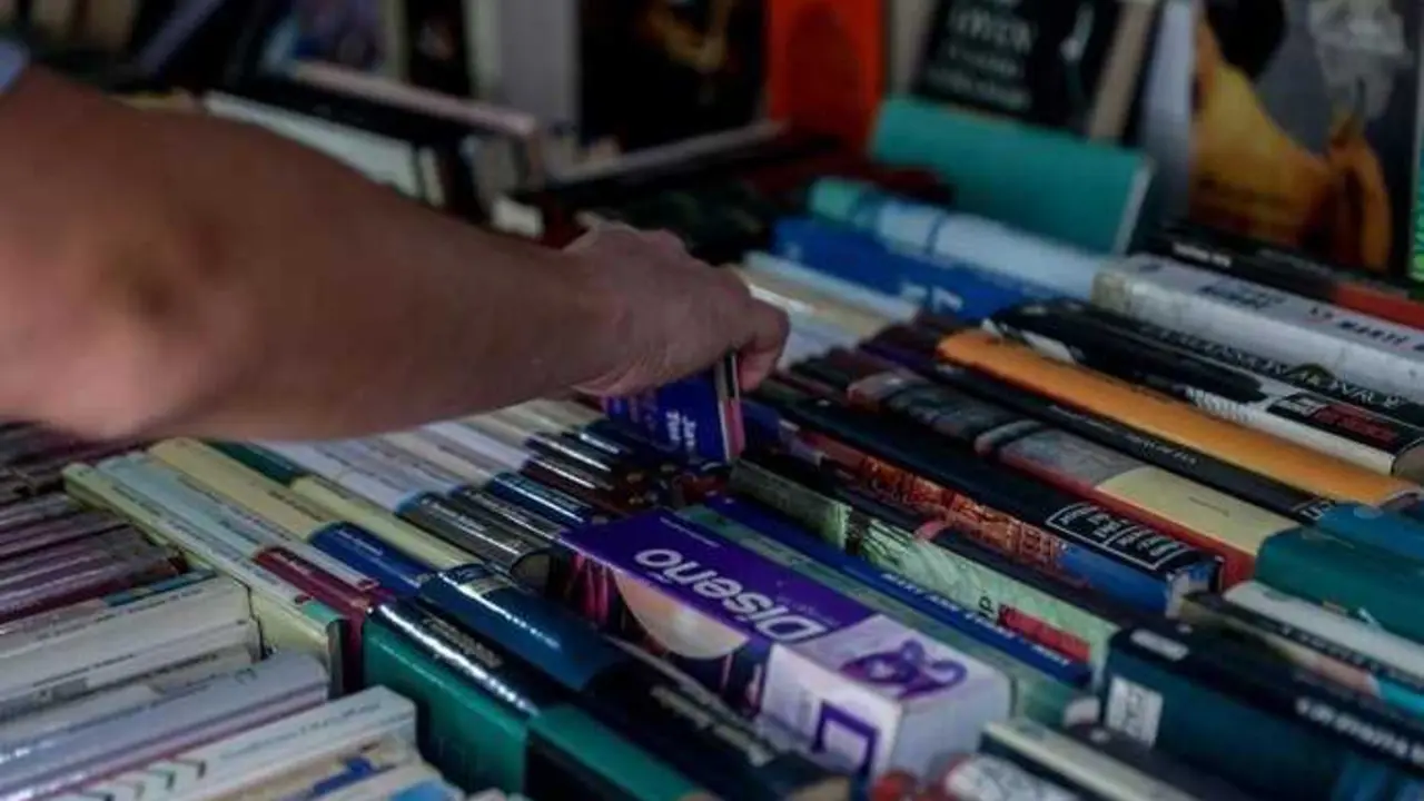 Archivo - Un joven escoge un libro en una librer&iacute;a.