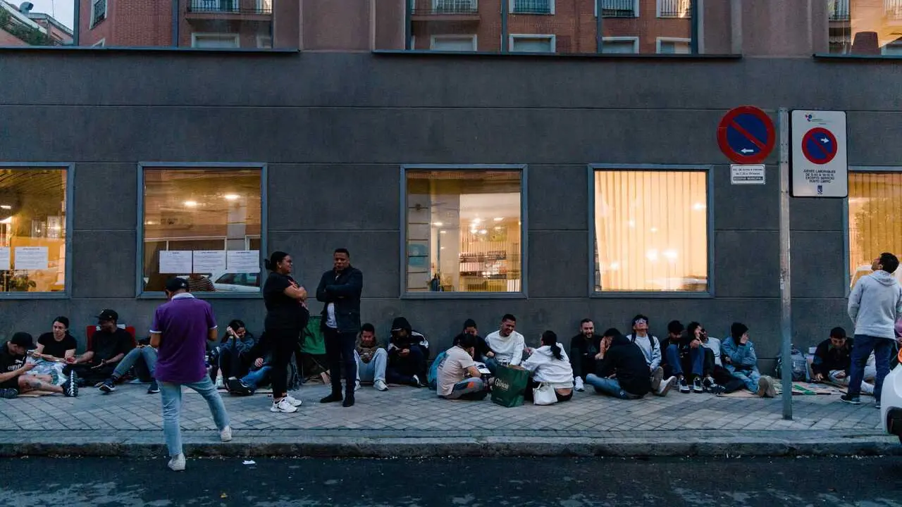 Varias personas hacen cola nocturna para conseguir el certificado de vulnerabilidad en una Oficina de Asistencia en Materia de Registro, a 21 de abril de 2026, en Madrid (Espa&ntilde;a). 