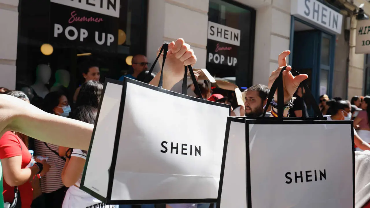 Archivo - Dos personas sujetan dos bolsas de Shein despu&eacute;s de entrar a la primera tienda f&iacute;sica de SHEIN en Madrid, a 2 de junio de 2022, en Madrid (Espa&ntilde;a). 