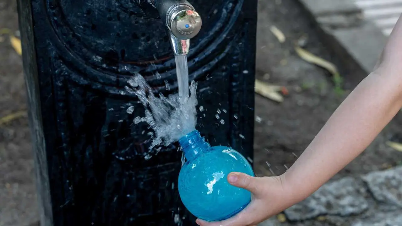 Archivo - Una persona llena un bote de agua en una fuente, en Madrid (Espa&ntilde;a). 