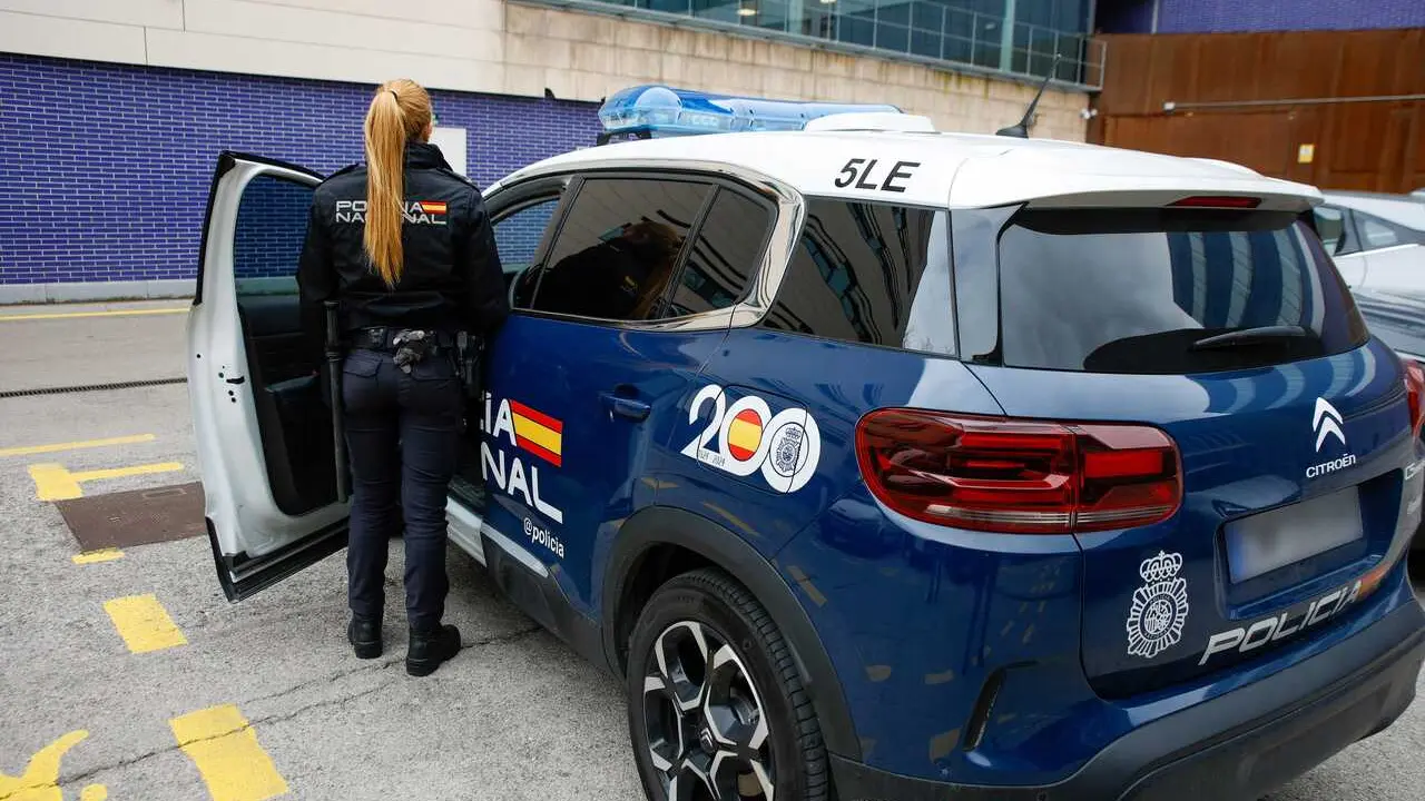 Archivo - Agente entrando a un veh&iacute;culo de la Polic&iacute;a Nacional en Barcelona