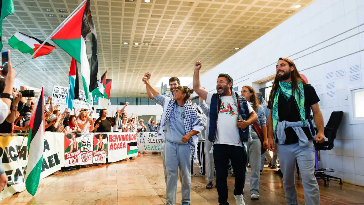 Los activistas Saif Abukeshek (c) y la secretaria de delegaciones de IAC y participante de la Flotilla, Ariadna Masmitj&agrave;, 'Masmi' (i), a su llegada al aeropuerto de El Prat, a 23 de mayo de 2026, en Barcelona, Catalunya (Espa&ntilde;a). 