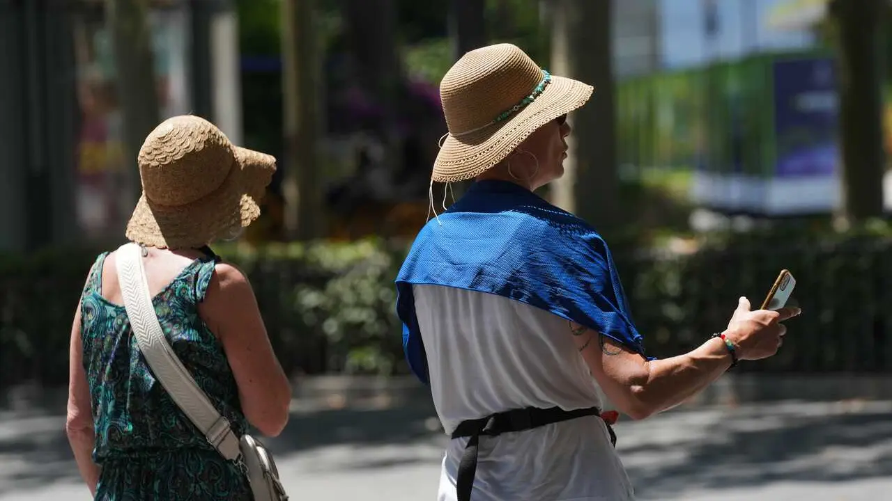 Turistas se protegen del calor por las calles de Sevilla. A 27 de mayo de 2026 en Sevilla, Andaluc&iacute;a (Espa&ntilde;a).