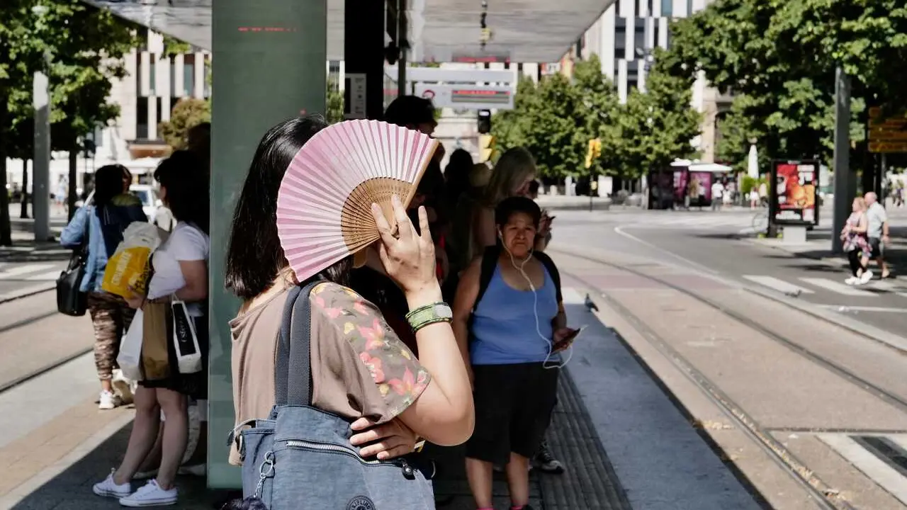 Archivo - Una mujer se tapa del sol con un abanico en la parada del tranv&iacute;a del Paseo de La Independencia, a 10 de julio de 2023, en Zaragoza, Arag&oacute;n (Espa&ntilde;a). 