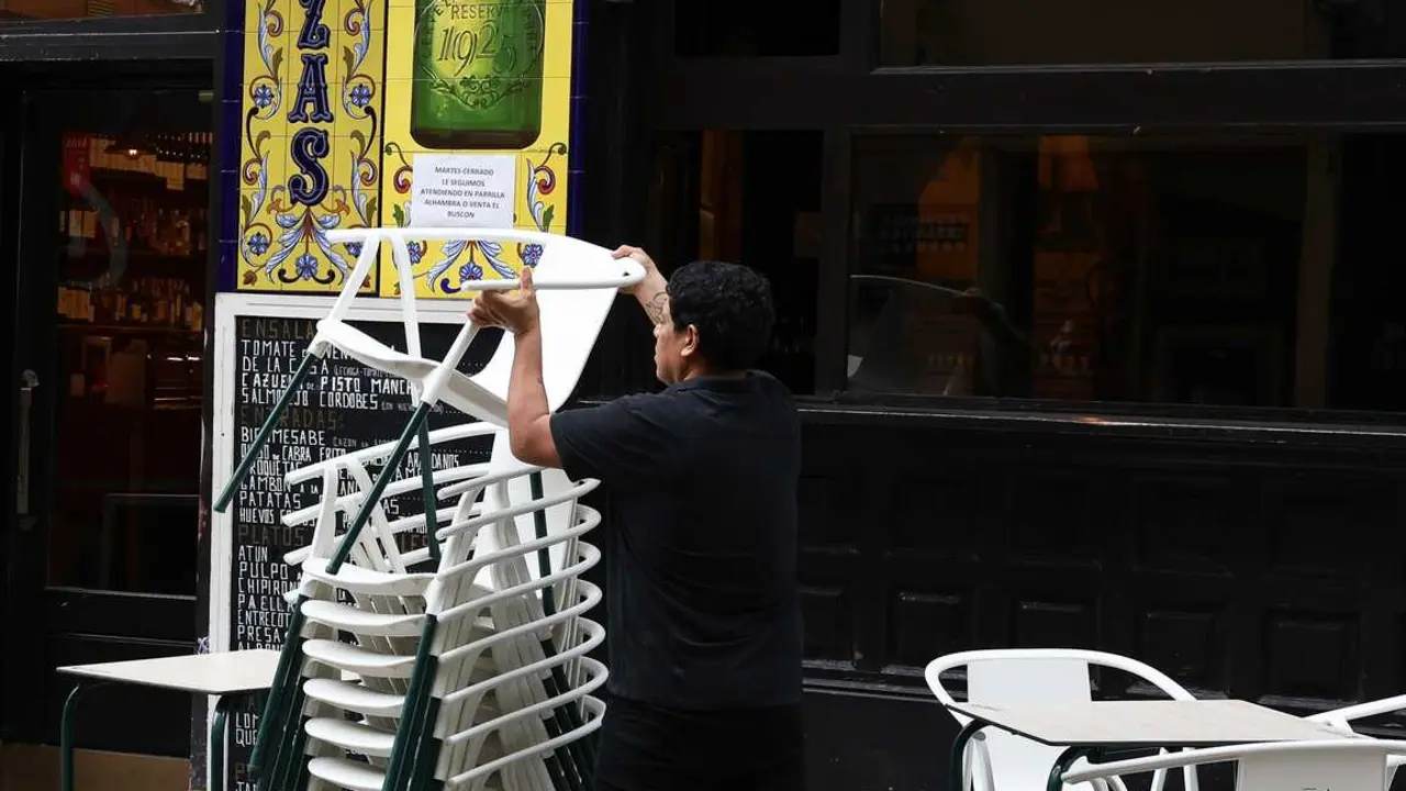 Archivo - Un camarero preparando las mesas de la terraza de un bar