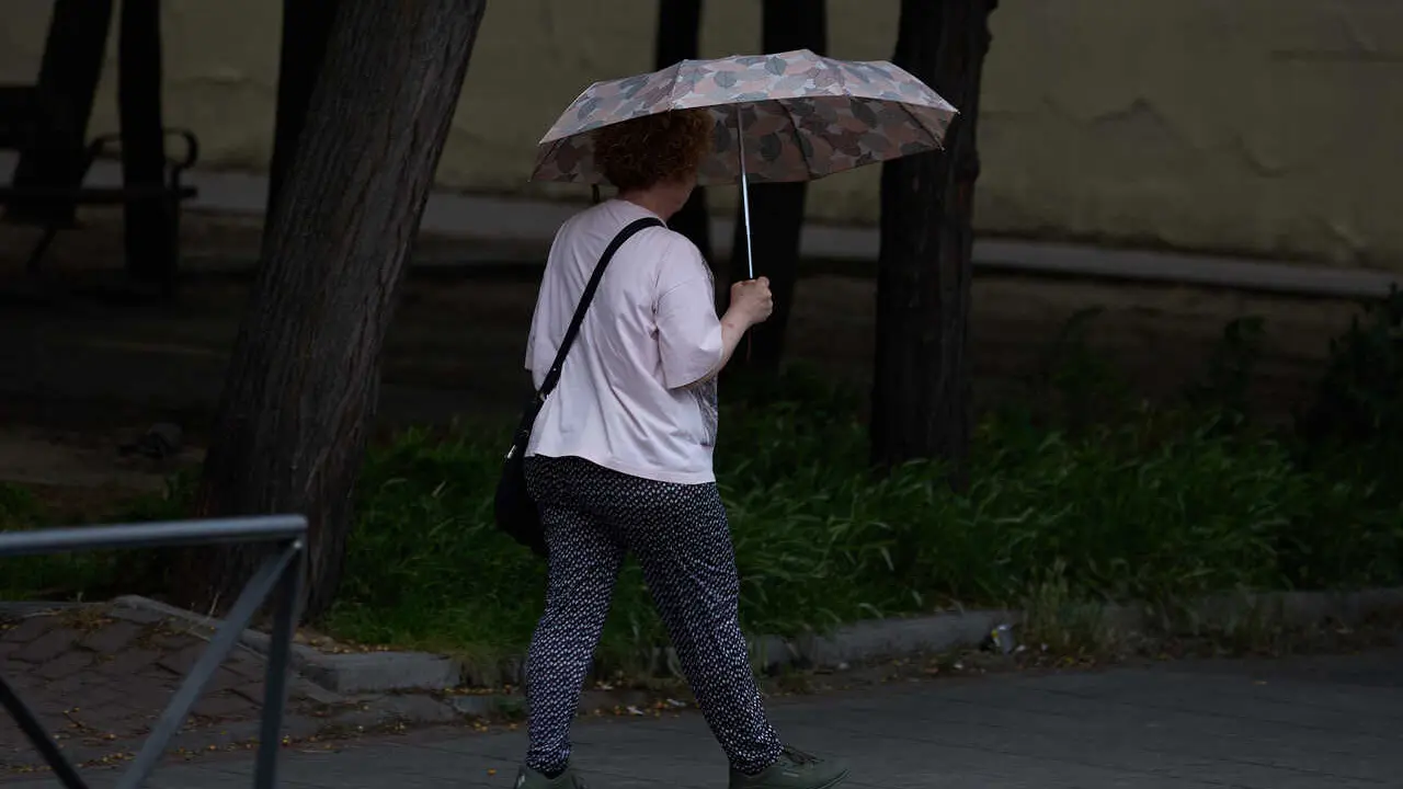 Archivo - Una mujer se protege de la lluvia con un paraguas, a 8 de junio de 2024, en Madrid (Espa&ntilde;a). 