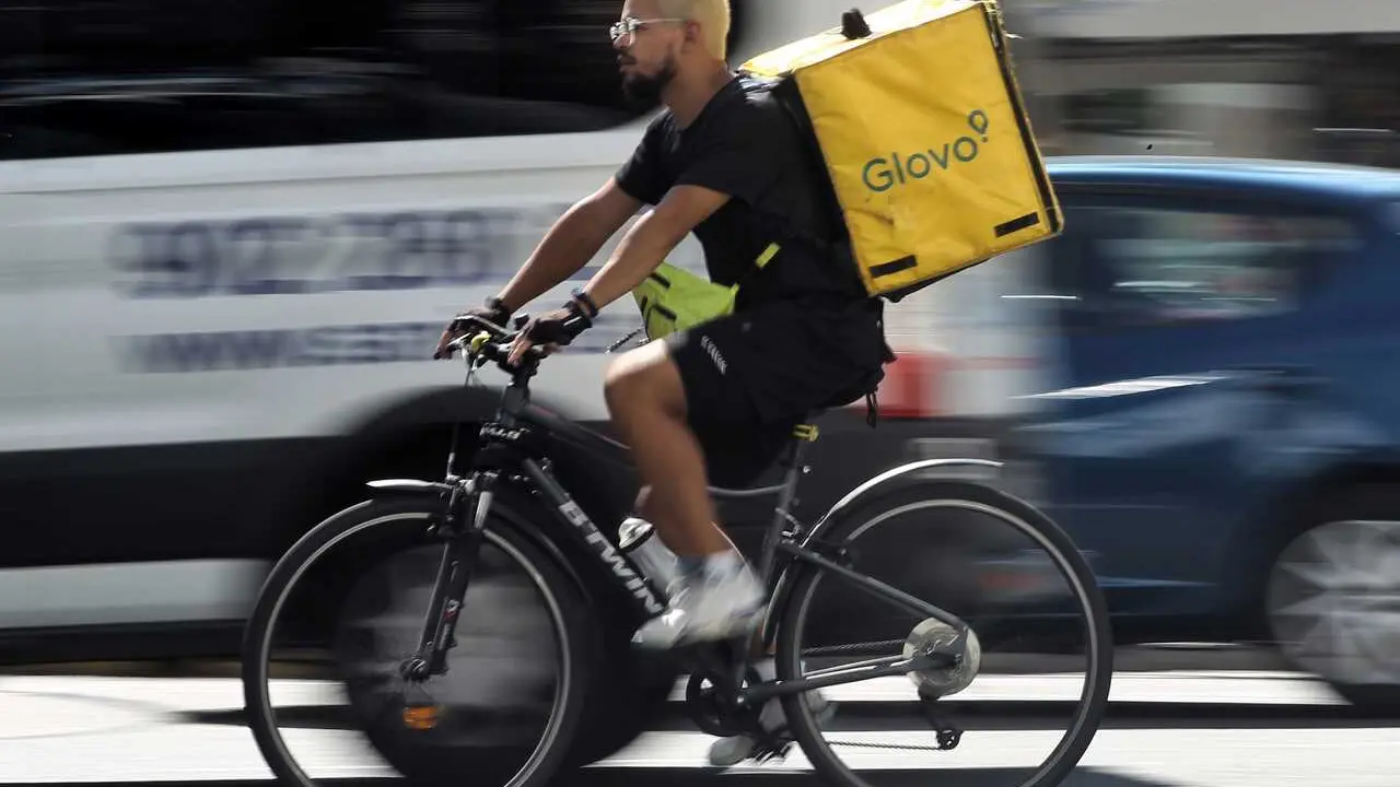 Archivo - Un rider de la empresa de reparto de comida a domicilio Glovo, pasea por una calle de Madrid con su bicicleta.