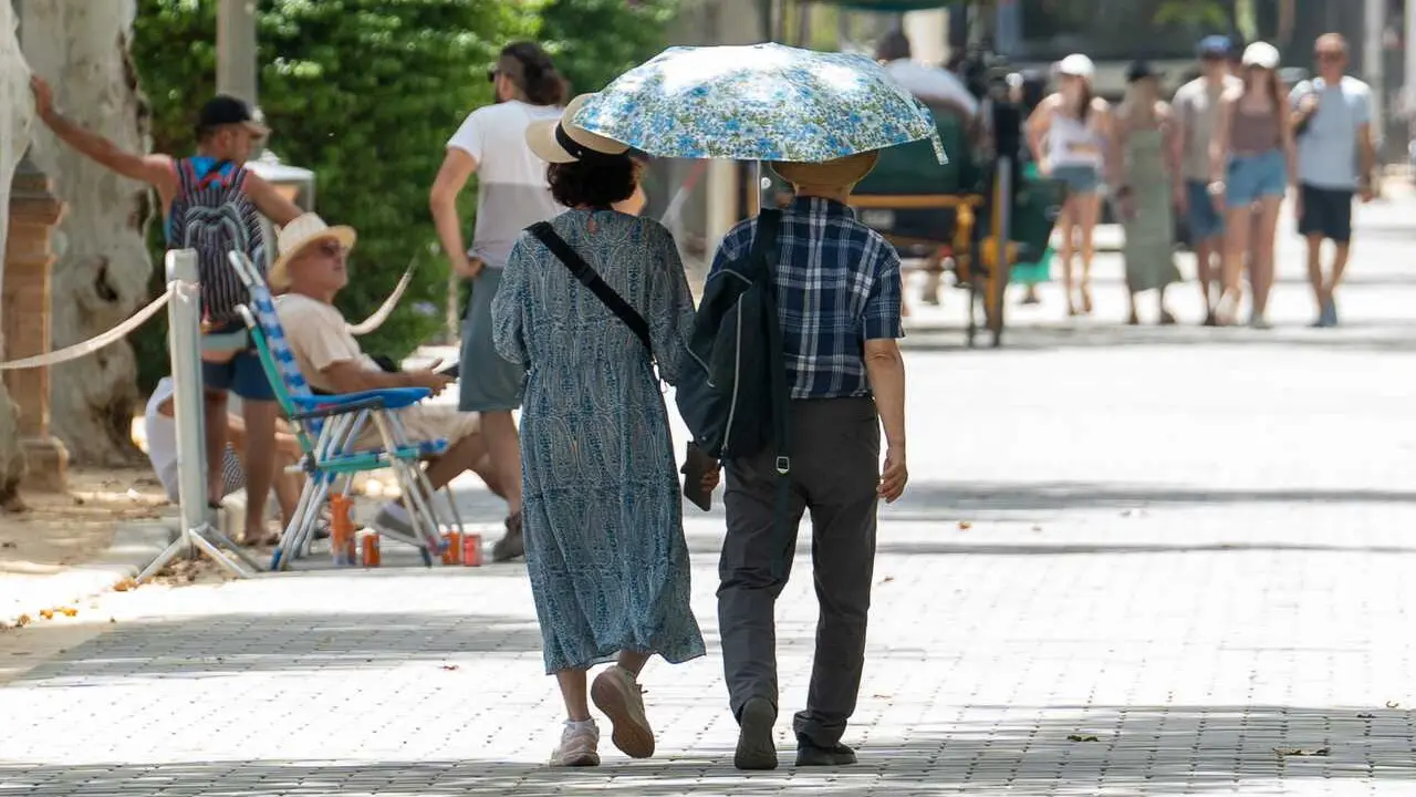 Archivo - Unos turistas pasean por la ciudad resguardados por un paraguas, a 19 de julio de 2024, en Sevilla, Andaluc&iacute;a (Espa&ntilde;a). La primera ola de calor del verano pone en alerta a Sevilla por altas temperaturas, tanto en la campi&ntilde;a como en la sierra nor