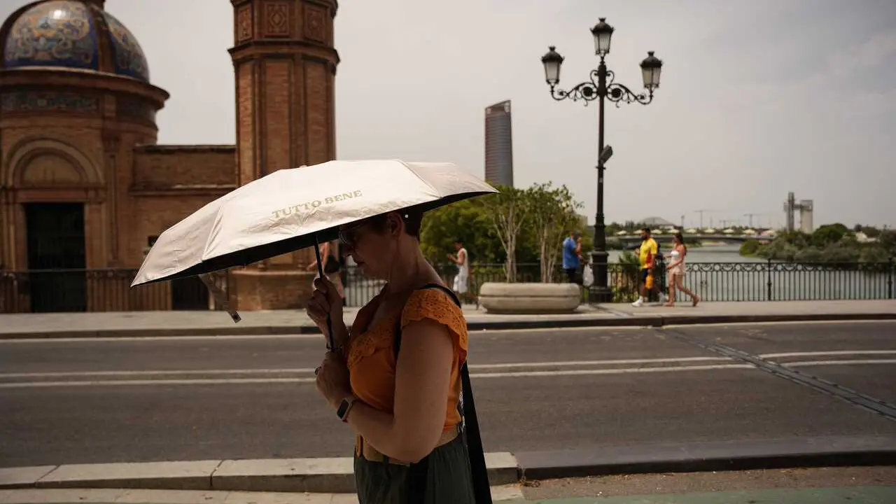 Una mujer se protege del sol con una sombrilla. A 23 de junio de 2026, en Sevilla (Andaluc&iacute;a, Espa&ntilde;a). 