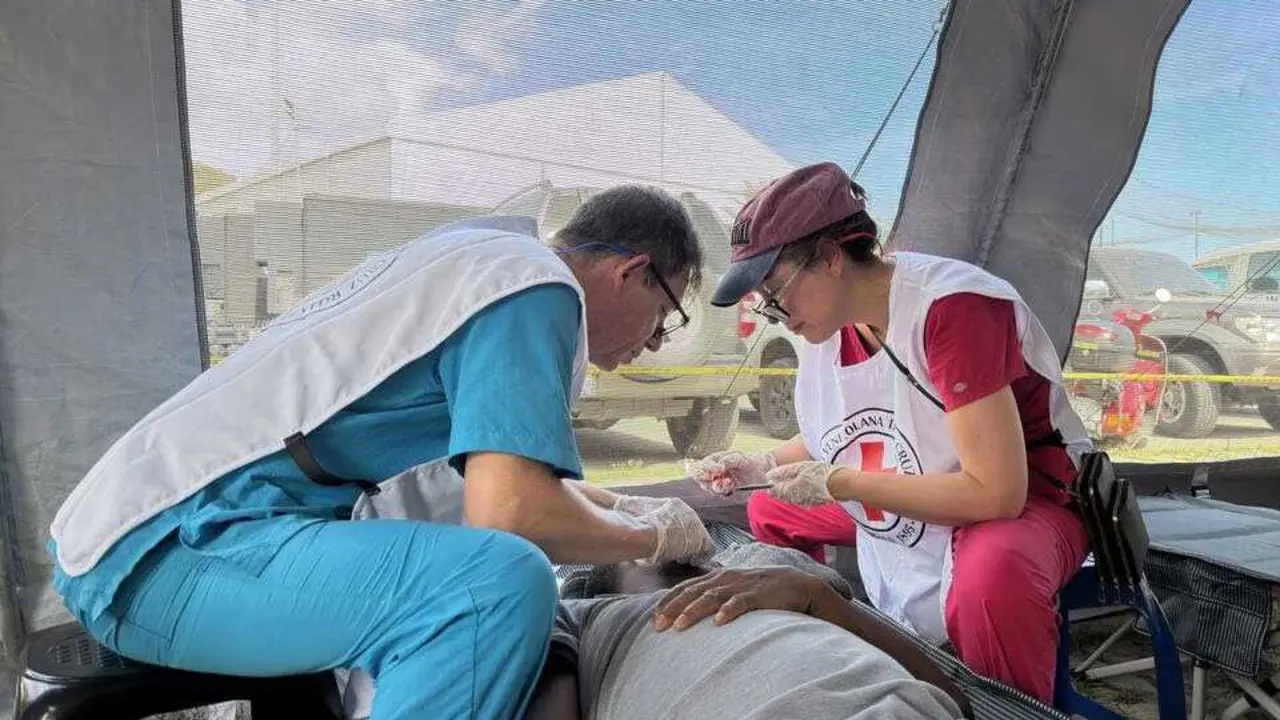 Dos sanitarios de Cruz Roja atienden a una persona.