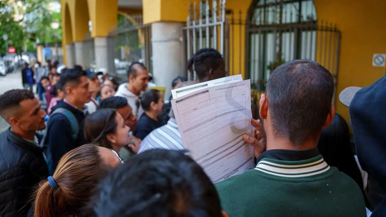 Archivo - Personas migrantes hacen cola para la tramitaci&oacute;n de su regularizaci&oacute;n administrativa en Sevilla.