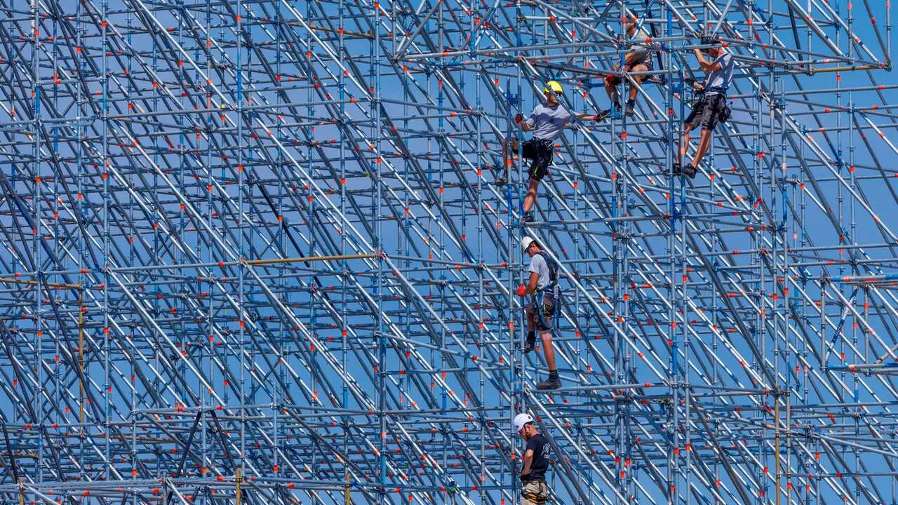 Trabajadores montando un escenario para un evento musical.