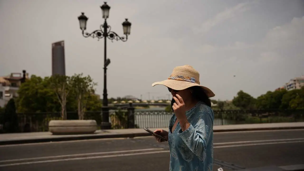 Una mujer se protege del sol con un sombrero. A 23 de junio de 2026, en Sevilla (Andaluc&iacute;a, Espa&ntilde;a).