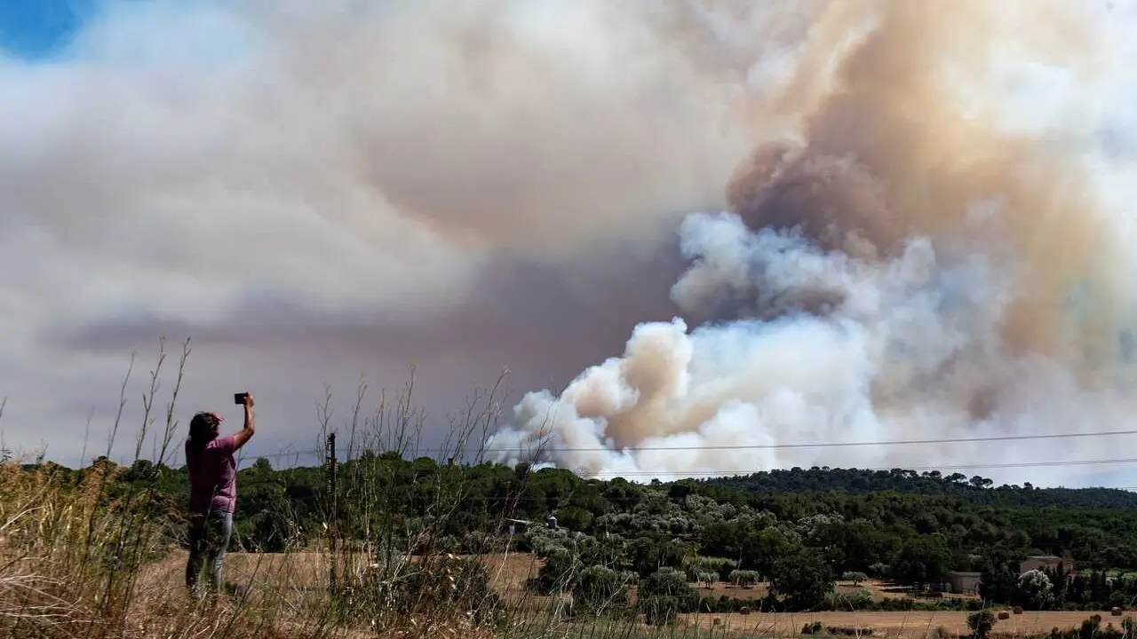 Una persona le hace una foto al humo del incendio, en La Bisbal d'Empord&agrave;, Girona, Catalunya (Espa&ntilde;a). Protecci&oacute; Civil ha enviado una alerta de forma preventiva por la evoluci&oacute;n del fuego, as&iacute; como la presencia de humo y para evitar la movilidad en la zon