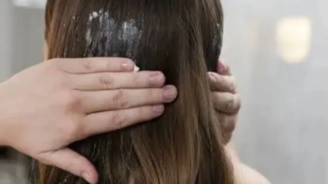 Mujer aplic&aacute;ndose mascarilla en el cabello