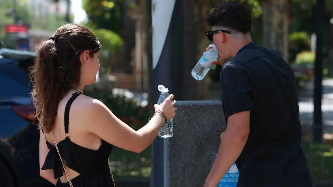 Una pareja bebe agua durante la ola de calor. A 05 de julio de 2026, en Sevilla (Andaluc&iacute;a, Espa&ntilde;a). Andaluc&iacute;a se sit&uacute;a como la comunidad que registra las temperaturas m&aacute;s altas durante la segunda ola de calor del verano, declarada el pasado viernes. En l