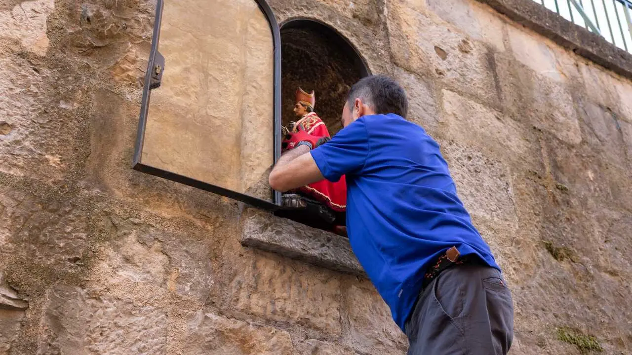 Operarios municipales colocan la imagen de San Ferm&iacute;n, propiedad del Ayuntamiento, en la hornacina de la cuesta de Santo Domingo tras el final de los Sanfermines 2026.