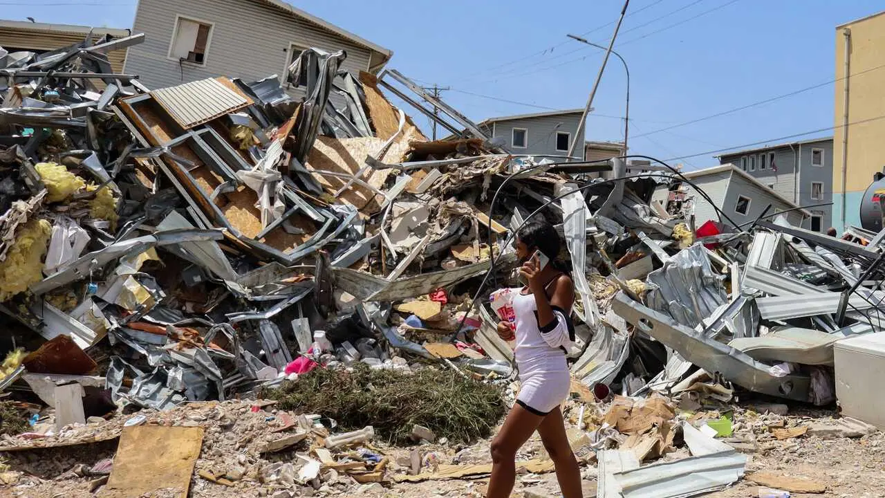 July 14, 2026, La Guaira, Venezuela: A woman walks past a collapsed building after last month�s twin earthquakes, which killed more than 4,700 people. Excavators and civil workers are carrying out controlled demolition and debris removal operations in the coastal community of Playa Grande, one of the areas hardest hit by the earthquake that struck northern Venezuela 20 days earlier. The operations have entered the recovery phase, focusing on clearing major roads blocked by collapsed residential buildings to restore access and mobility for residents as reconstruction efforts continue. (Credit Image: � Mario Flores/JNA via ZUMA Press Wire)