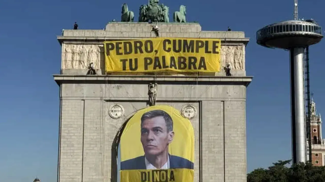 Activistas despliegan una pancarta en el arco de Moncloa