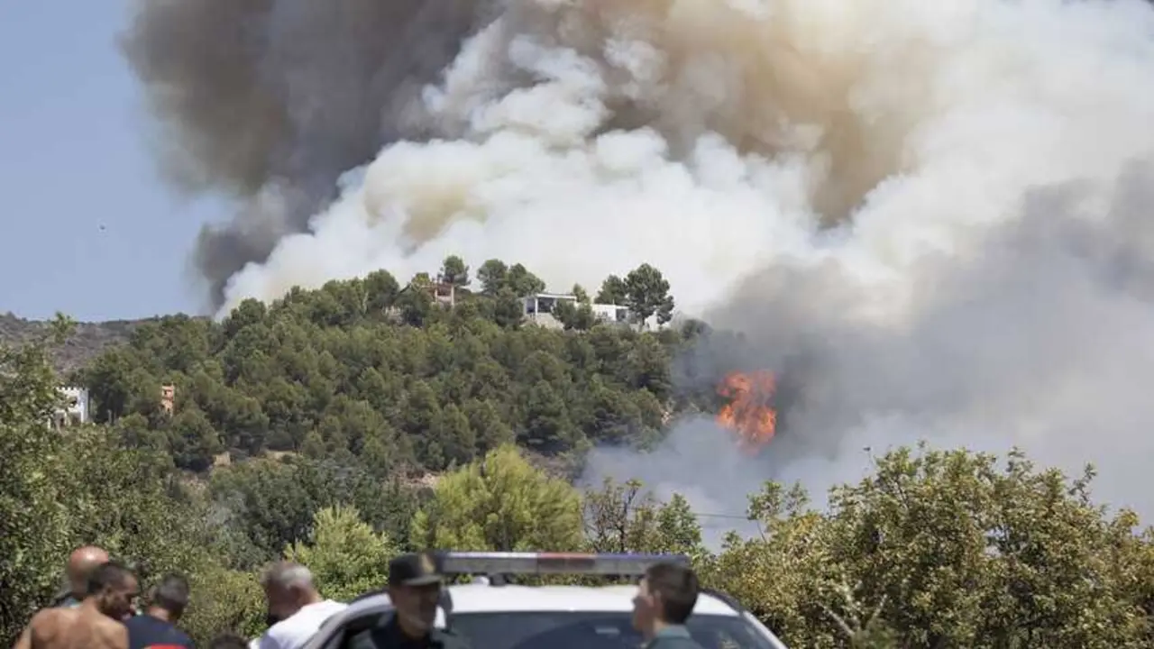Varias personas y guardia civil durante las labores de extinci&oacute;n de un incendio forestal en Vall d'Uix&oacute;, Castell&oacute;n