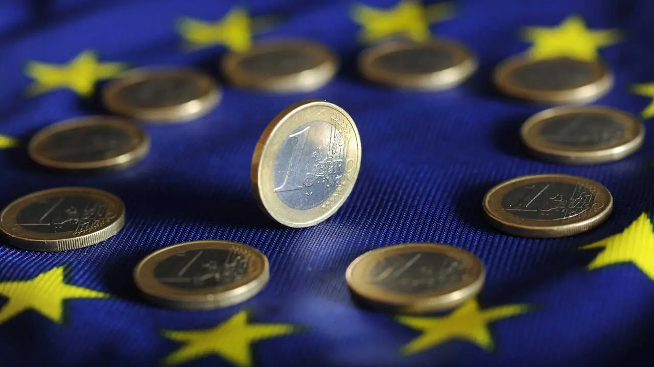 Archivo - Monedas de euro sobre una bandera europea