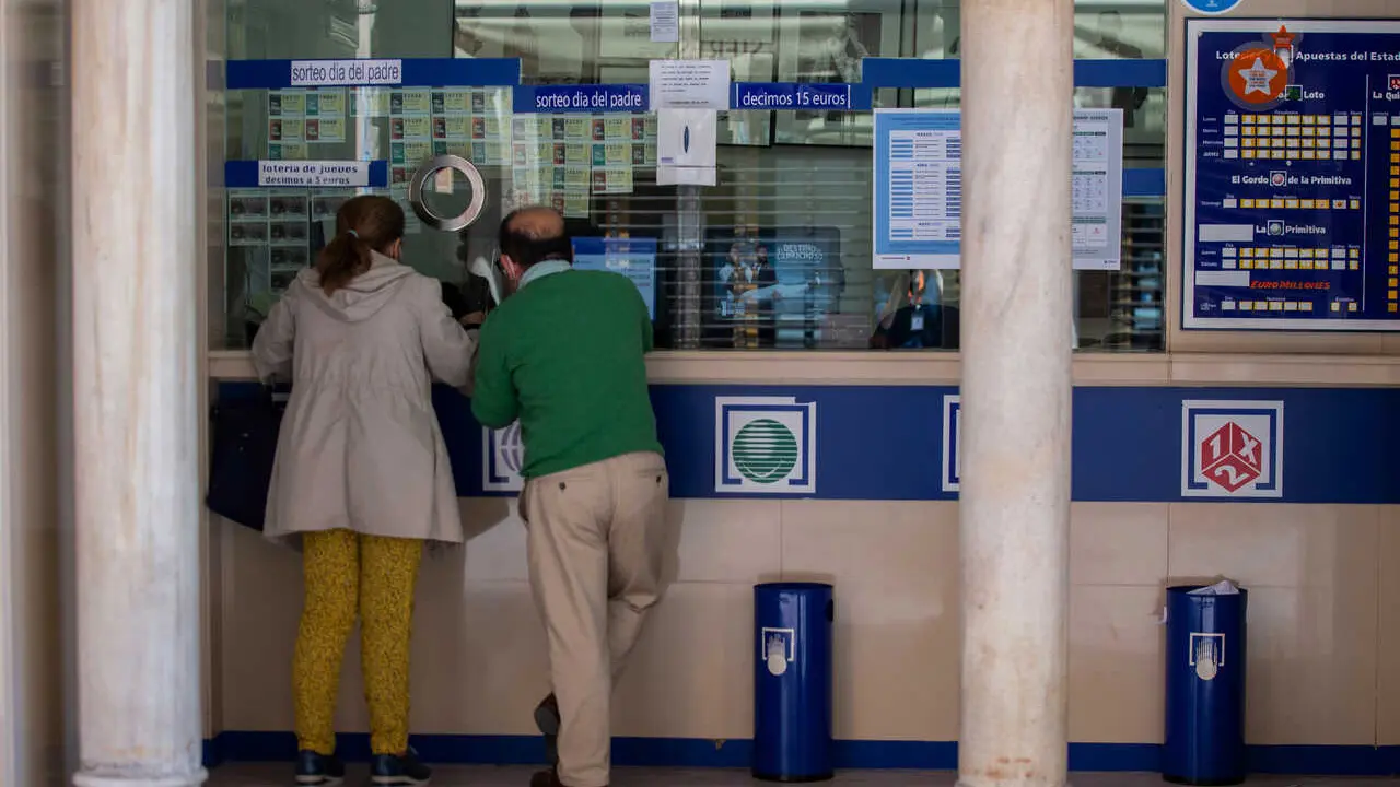 Archivo - Dos personas compran loter&iacute;a en una Administraci&oacute;n.