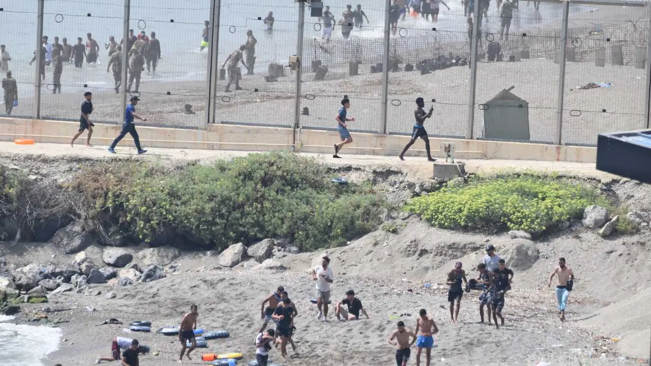 Varios migrantes intentan cruzar la frontera, a 30 de julio de 2026, en Ceuta (Espa&ntilde;a).