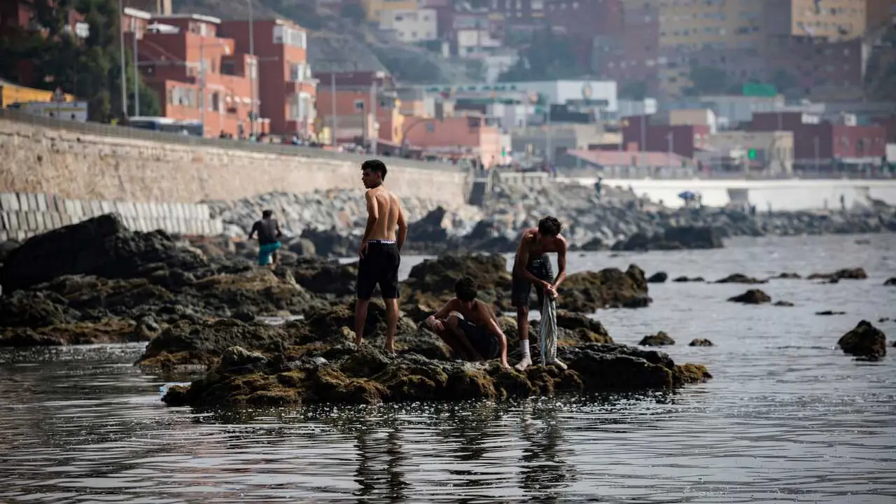 01 August 2026, Spain, Ceuta: Migrants who remained in Ceuta cross back into Morocco through the Tarajal border crossing during the early morning hours. P 