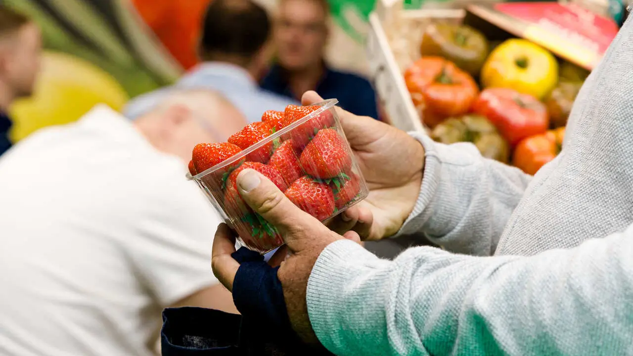 Archivo - Un hombre comprando una cajita de fresas