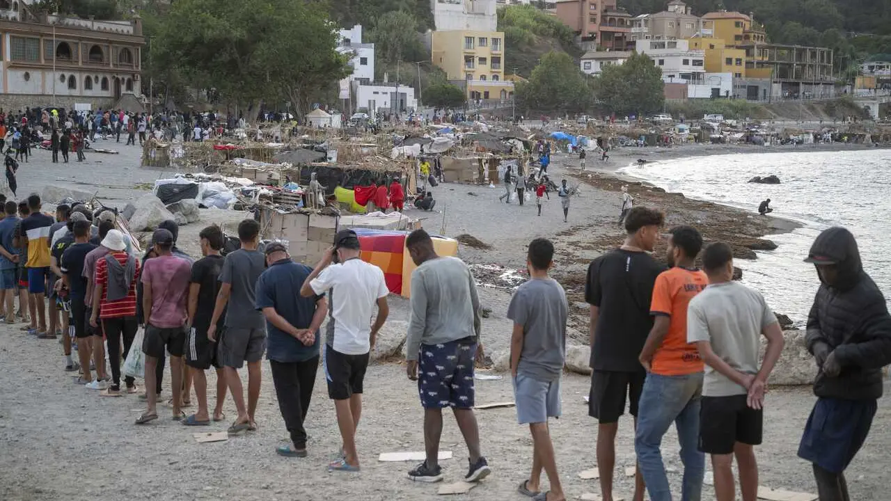 Varios inmigrantes en una playa, a 19 de agosto de 2026, en Ceuta (Espa&ntilde;a).