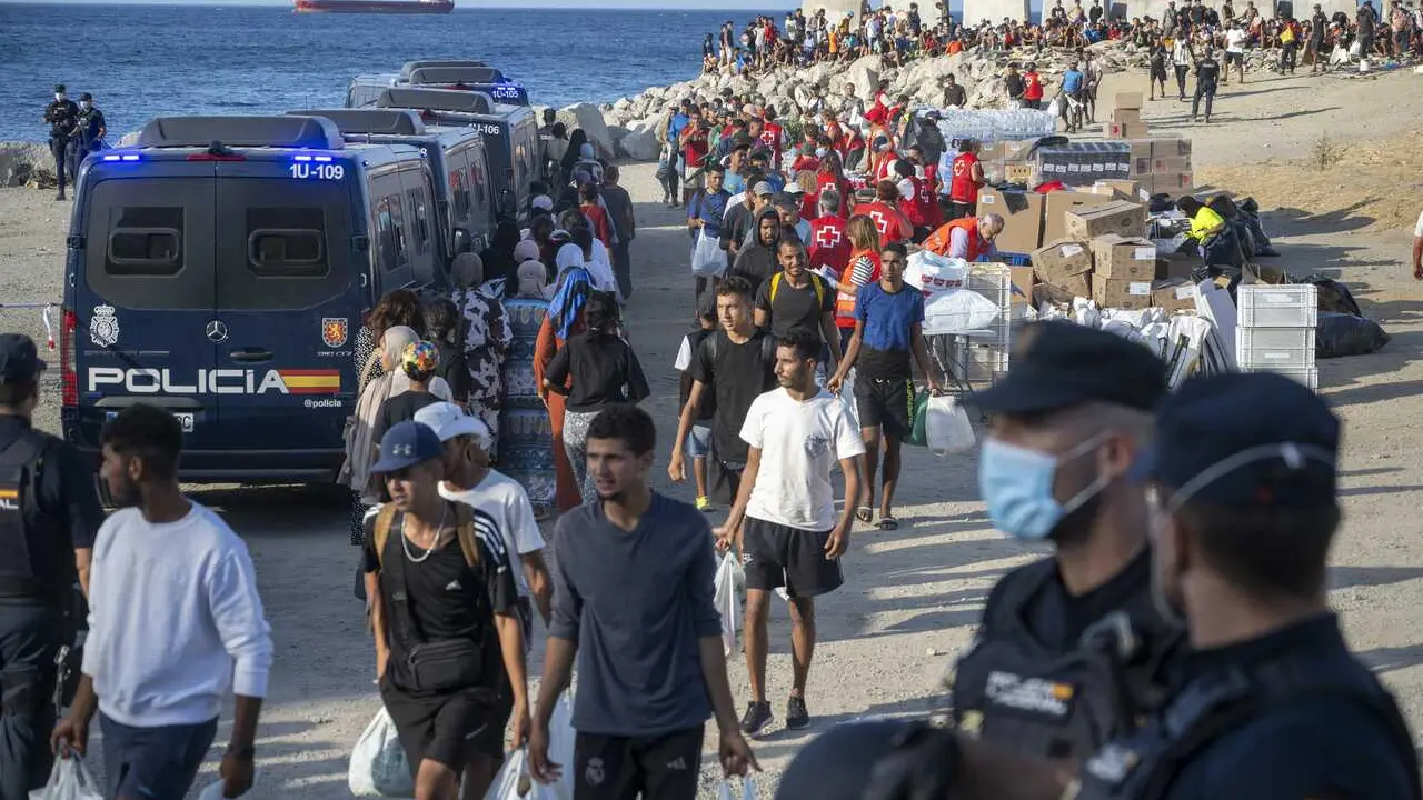 Miembros de la Cruz Roja atienden a varios inmigrantes, en la playa del Trampol&iacute;n, a 20 de agosto de 2026, en Ceuta (Espa&ntilde;a)