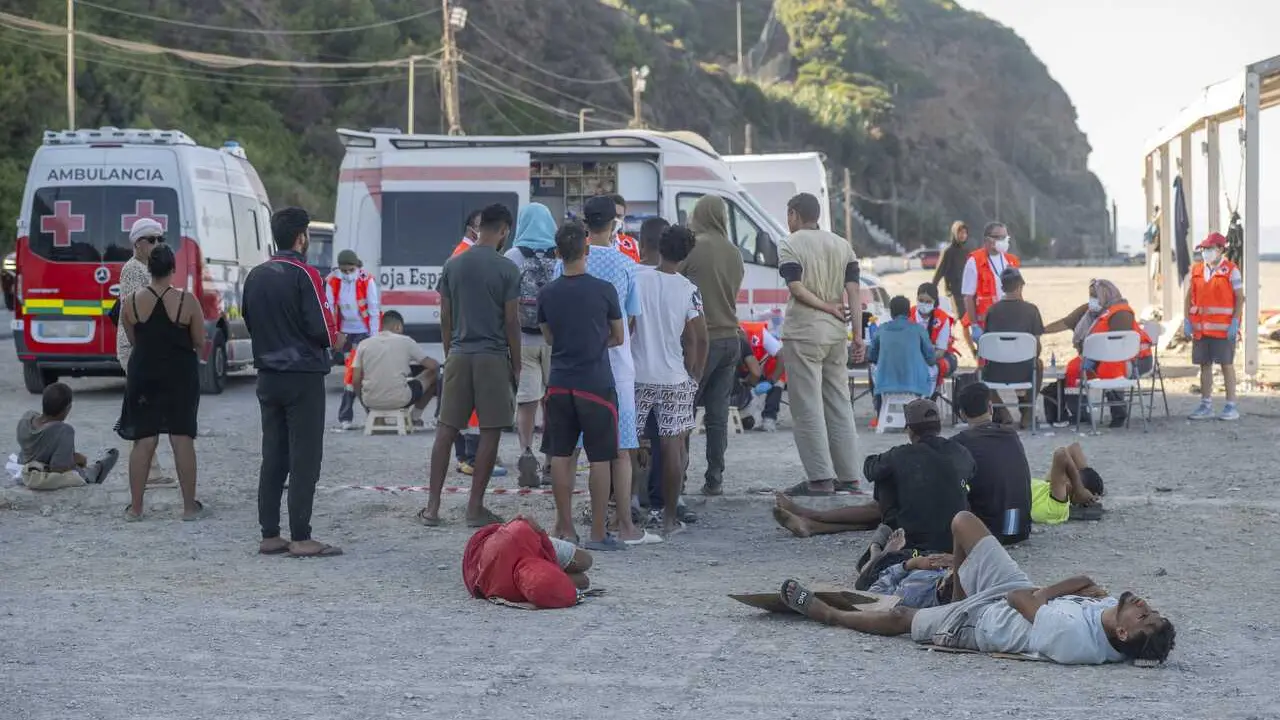 Miembros de la Cruz Roja atienden a los inmigrantes en una playa, a 21 de agosto de 2026, en Ceuta (Espa&ntilde;a). 