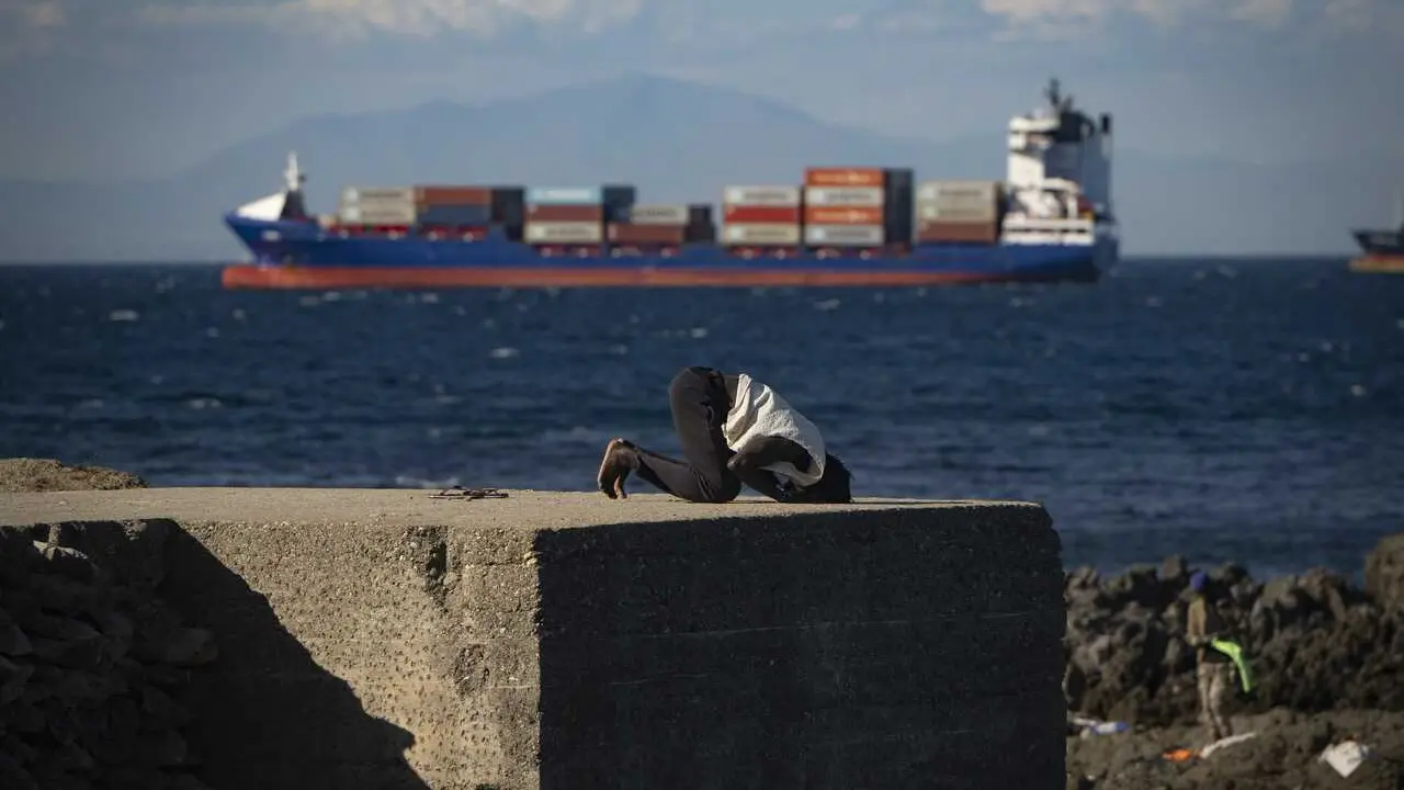 Un inmigrante reza en una playa, a 21 de agosto de 2026, en Ceuta (Espa&ntilde;a)