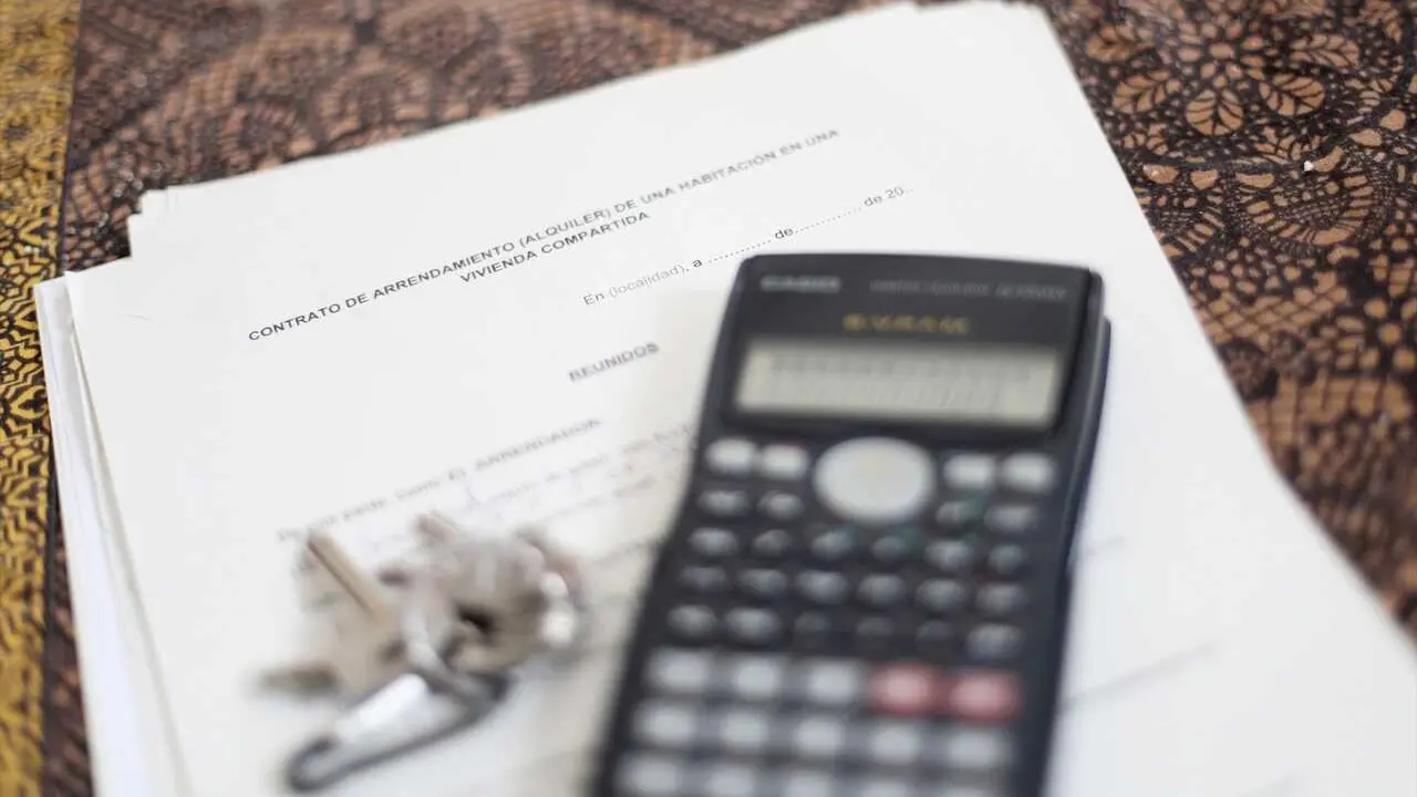  Una calculadora y unas llaves sobre un contrato de alquiler de una habitaci&oacute;n en una vivienda compartida.