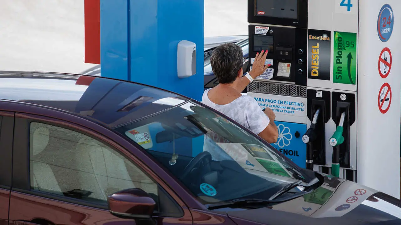 Archivo - Una mujer antes de echar carburante a su veh&iacute;culo en una estaci&oacute;n de servicio