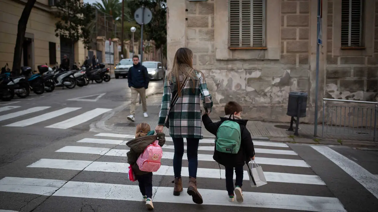 Archivo - Dos ni&ntilde;as de la mano con una mujer a su llegada al primer d&iacute;a de clase presencial tras la Navidad, a 10 de enero de 2022, en Barcelona, Catalunya, (Espa&ntilde;a). 