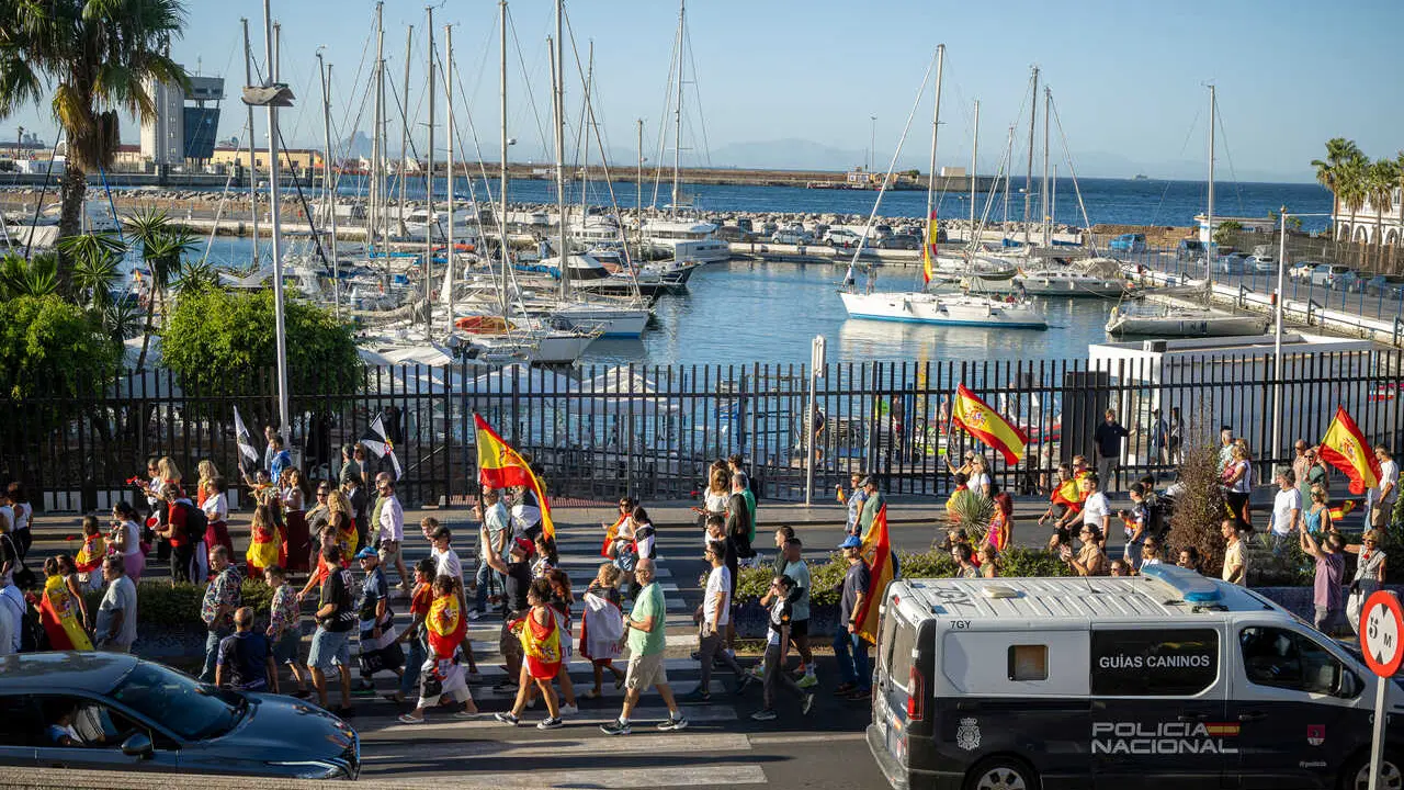 Numerosas personas portan claveles y banderas de Espa&ntilde;a durante una manifestaci&oacute;n ante la Delegaci&oacute;n del Gobierno, a 28 de agosto de 2026, en Ceuta (Espa&ntilde;a). 